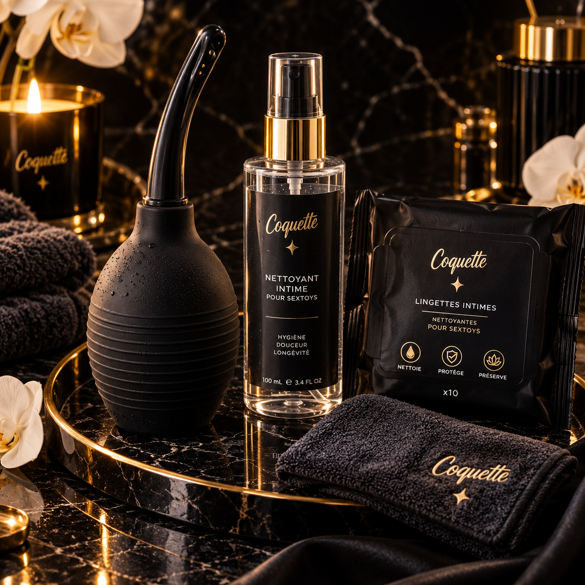Accessoires de préparation et d’hygiène intime avec poire de nettoyage, nettoyant pour sextoys et lingettes sur fond noir et doré.