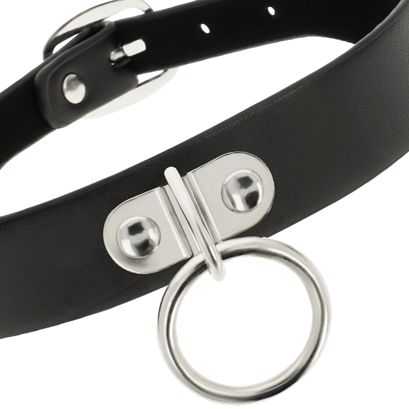 Gros plan sur le cuir végan noir, les rivets et l'anneau métallique du collier