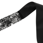 Gros plan de la dentelle florale noire et du ruban du masque Coquette Chic Desire