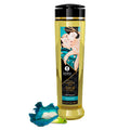 Flacon d’huile de massage Shunga Sensuelle Fleurs des îles 240 ml, accompagné d’une fleur bleue